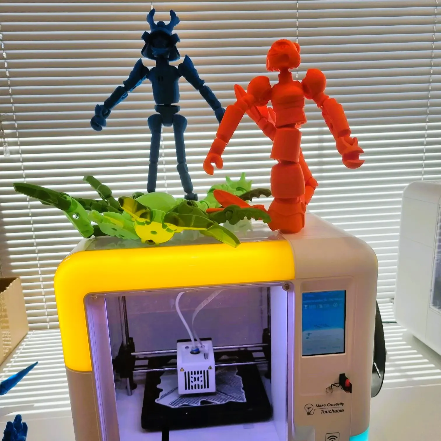 Wydrukowane figurki ustawione na małej drukarce 3D