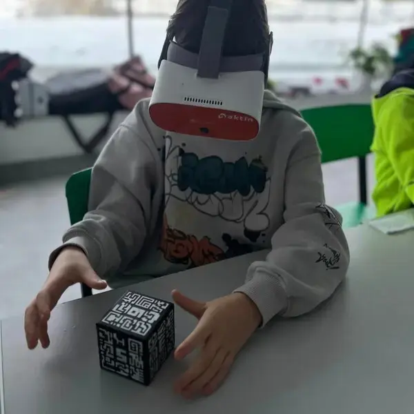 Dziecko w goglach VR trzyma kostkę z markerami